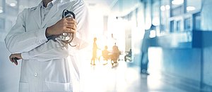 Arzt mit Stethoskop steht in Krankenhaus
