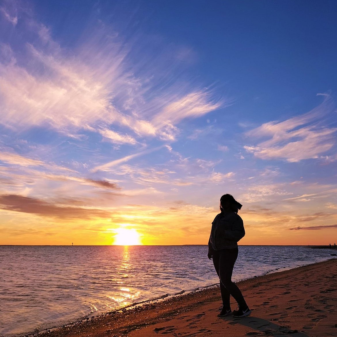 Weibliche Person am Strand mit Sonnenuntergang