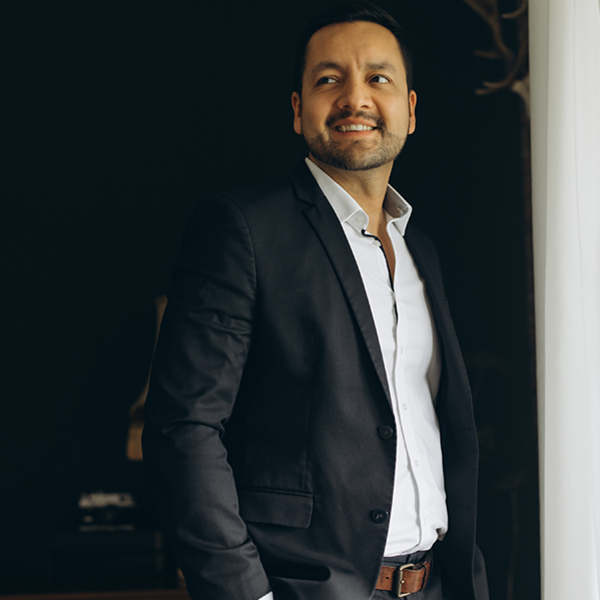 Alumni Eduardo Rodriguez aus Mexiko blickt in Hemd und Jacket lächelnd in die Kamera