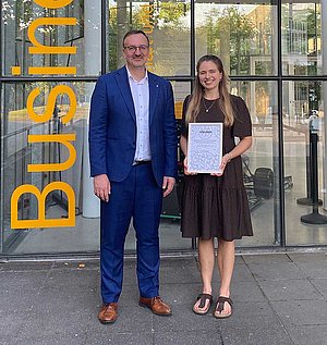 Anja Körnle erhält einen Förderpreis vom Rotary Club Pforzheim für ihre Masterarbeit. Die Urkunde wird ihr von Kai Sternad, Präsident des Rotary Clubs, überreicht 