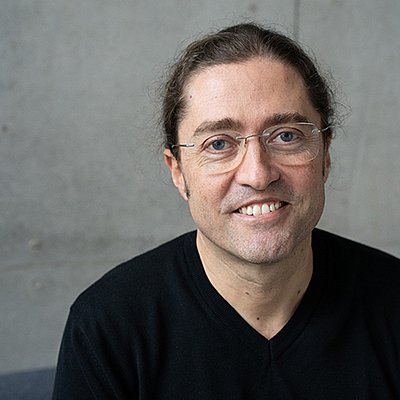 Prof. Dr. Fernando Fastoso in einem schwarzen Pullover vor grauem Hintergrund