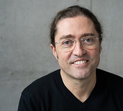 Prof. Dr. Fernando Fastoso in einem schwarzen Pullover vor grauem Hintergrund