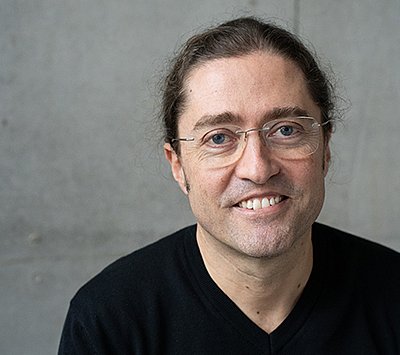 Prof. Dr. Fernando Fastoso in einem schwarzen Pullover vor grauem Hintergrund