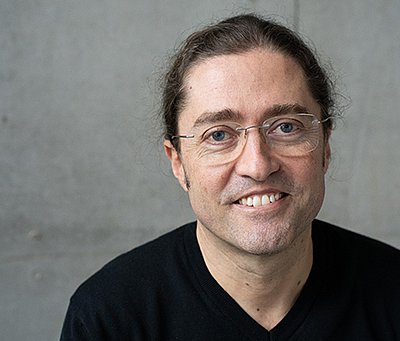 Prof. Dr. Fernando Fastoso in einem schwarzen Pullover vor grauem Hintergrund
