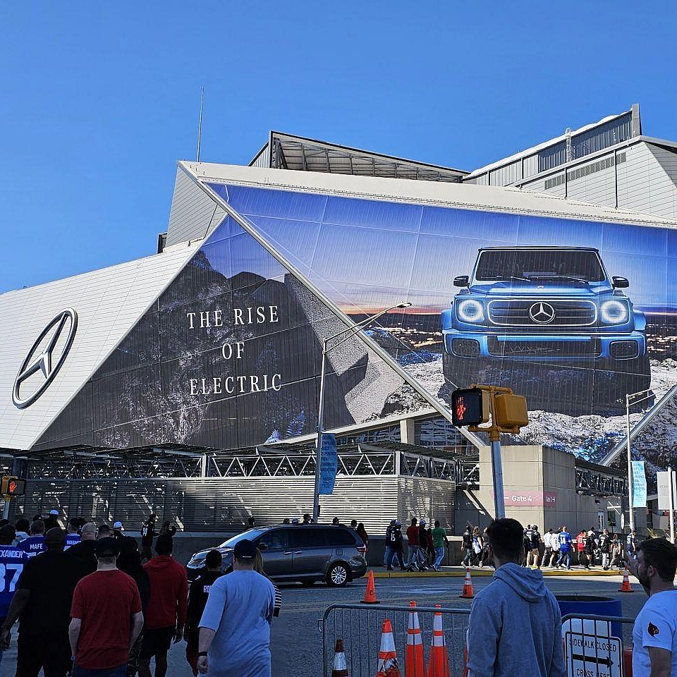 Exterior view of the Mercedes-Benz Arena in Atlanta, known for its futuristic retractable roof and glass facade