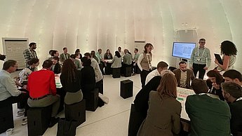 ca. 40 Workshopteilnehmende sitzend an drei Tischen