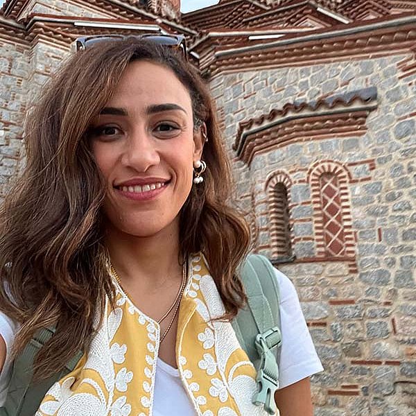 Alumna Yousra Emara aus Ägypten steht vor einem orientalisch aussehenden Gebäude