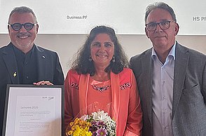 Preisträgerin Brigitte Burkart mit einem Blumenstrauß in der Hand, links von ihr steht Prof. Dr. Thomas Cleff mit Urkunde, rechts davon Prof. Dr. Marcus-Oliver Schwaab